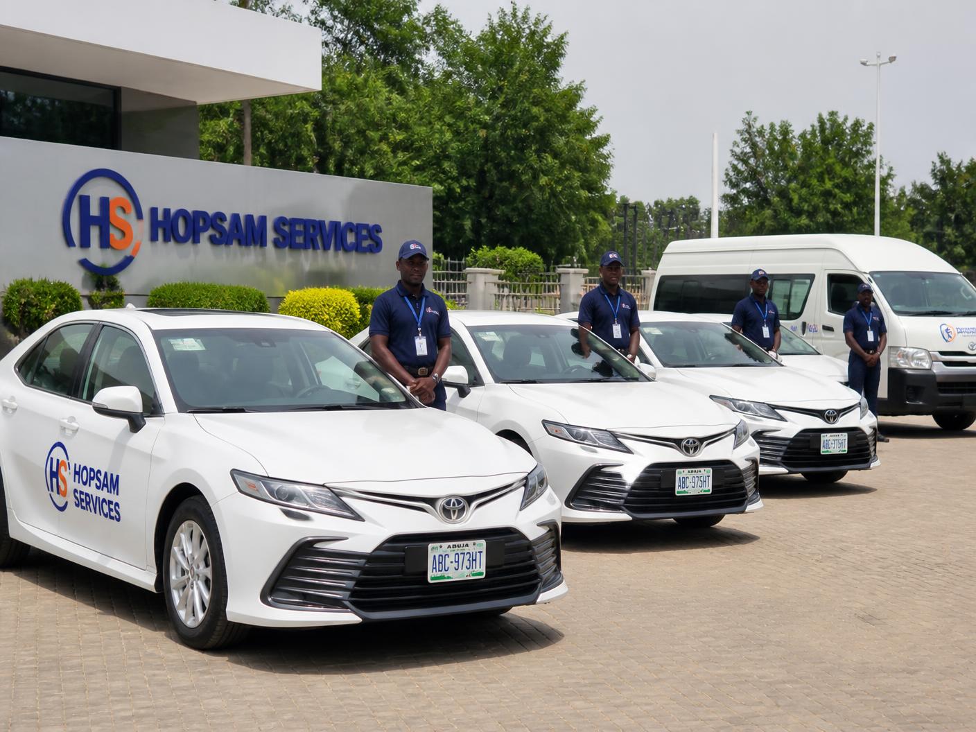 Hopsam Services branded white Toyota Camry saloons and passenger van with HS logo livery and drivers in Abuja, Nigeria